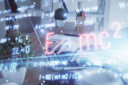 Double exposure of woman hands typing on computer and formula hologram drawing. Education concept.の写真素材