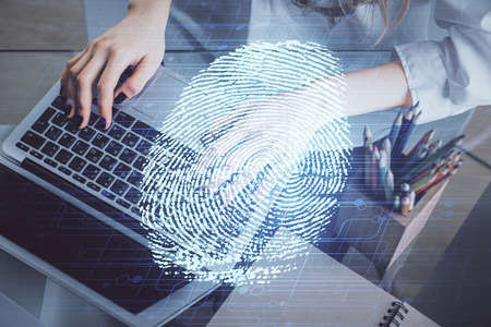 Double exposure of woman hands typing on computer and fingerprint drawing. Security concept.の写真素材
