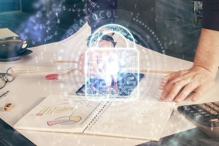 Multi exposure of man's hands holding and using a digital device and lock drawing. Security concept.の写真素材