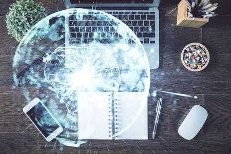 Business theme hologram drawings over computer on the desktop background. Top view. Multi exposure. Concept of international connections.の写真素材