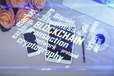 Double exposure of blockchain theme hologram over table with phone. Top view. Crypto technology concept.の写真素材