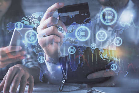 Double exposure of man and woman on-line shopping holding a credit card and forex graph hologram...