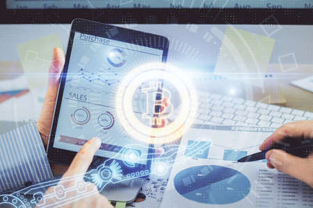 Double exposure of man's hands holding and using a phone and crypto currency blockchain theme...