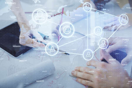 Double exposure of social network theme drawing and man and woman working together holding and using...