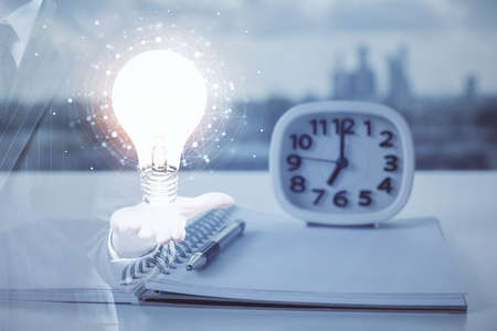 Double exposure of bulb drawing and desk with open notebook background. Concept of ideaの写真素材