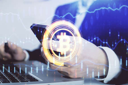 Double exposure of man's hands holding and using a phone and crypto currency blockchain theme...