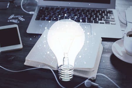 Double exposure of bulb drawing and desk with open notebook background. Concept of idea