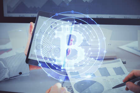Double exposure of man's hands holding and using a phone and crypto currency blockchain theme...