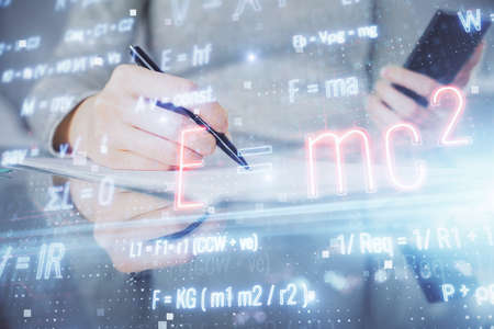 Double exposure of formulas sketch hologram and woman holding and using a mobile device. Education...