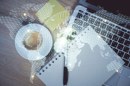 Business theme hologram drawings over computer on the desktop background. Top view. Multi exposure. Concept of international connections.の写真素材