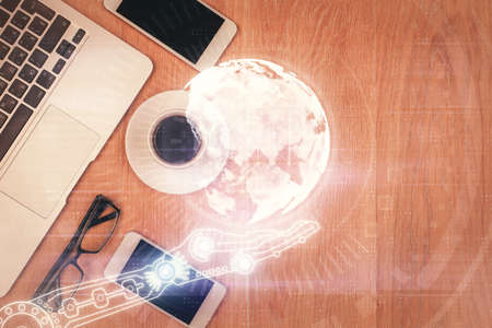 Double exposure of map hologram drawing over desktop. Top view. International connection concept.