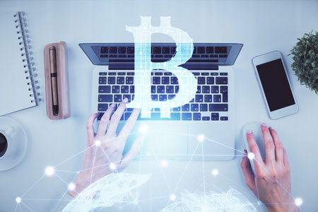 Double exposure of woman hands working on computer and blockchain theme hologram drawing. Top View. bitcoin cryptocurrency concept.の写真素材