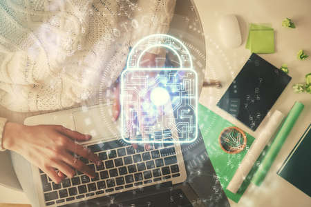 Double exposure of woman hands working on computer and lock hologram drawing. Top View. Security concept.の写真素材