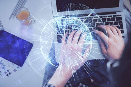 Double exposure of mans hands typing over computer keyboard and business theme hologram drawing. Top...