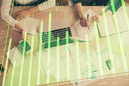 Double exposure of woman hands working on computer and forex graph hologram drawing. Top View....