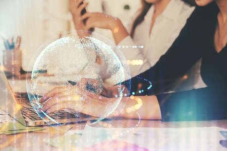 Double exposure of woman hands working on computer and world map hologram drawing. International technology business concept.の写真素材