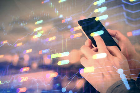 Double exposure of man's hand holding and using a digital device and data theme hologram drawing....