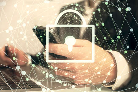 Multi exposure of man's hands holding and using a digital device and lock drawing. Security concept.の写真素材