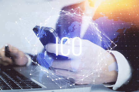 Double exposure of man's hands holding and using a phone and crypto currency blockchain theme drawing.の写真素材