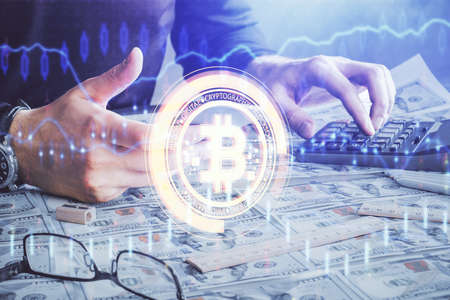 Double exposure of man's hands holding and using a phone and crypto currency blockchain theme...