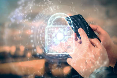 Multi exposure of man's hands holding and using a digital device and lock drawing. Security concept.の写真素材