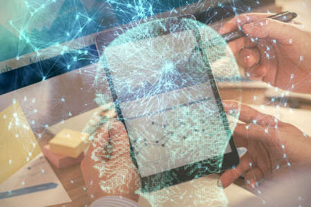 Double exposure of man's hand holding and using a digital device and brain hologram drawing. Data concept.の写真素材