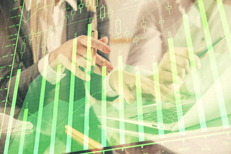 Multi exposure of man and woman working together and financial chart hologram. Business concept....