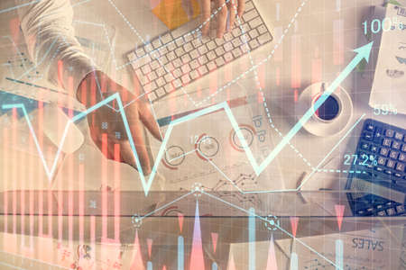 Multi exposure of man's hands typing over computer keyboard and forex graph hologram drawing. Top view. Financial markets concept.の写真素材