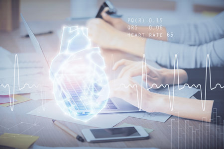 Double exposure of woman hands typing on computer and heart hologram drawing. Education concept.