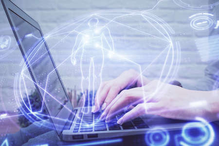 Double exposure of woman hands typing on computer and general theme hologram drawing. Education concept.の写真素材