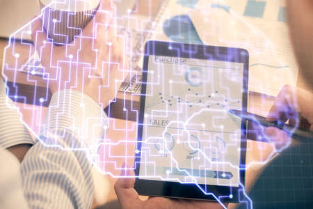 Double exposure of man's hand holding and using a digital device and brain hologram drawing. Data...