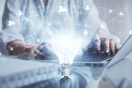 Double exposure of woman hands typing on computer and light bulb drawing. Idea concept.の写真素材