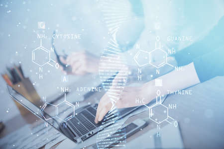 Double exposure of woman hands typing on computer and DNA hologram drawing. Medical education concept.の写真素材