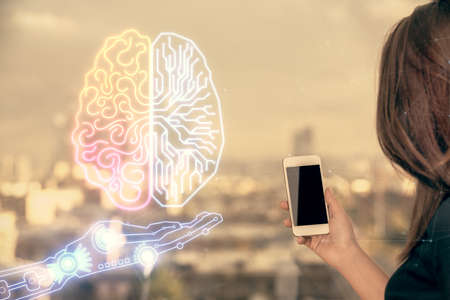 Double exposure of brain sketch hologram and woman holding and using a mobile device.