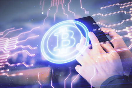 Double exposure of man's hands holding and using a phone and crypto currency blockchain theme...