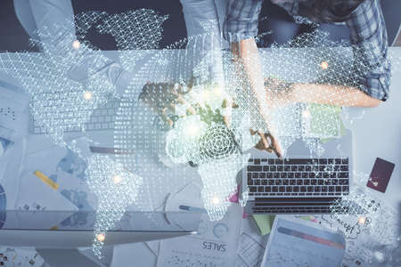 Double exposure of man and woman working together and business theme hologram drawing. Computer background. Top View.の写真素材