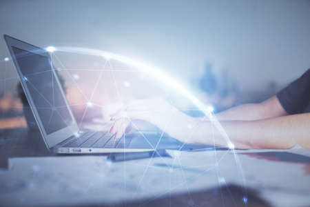 Double exposure of woman hands typing on computer and social network theme hologram drawing. People...