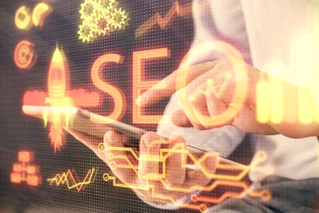 Multi exposure of man's hands holding and using a digital device and seo drawing. search...