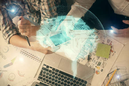 Double exposure of man and woman working together holding and using a mobile device and brain hologram drawing.の写真素材