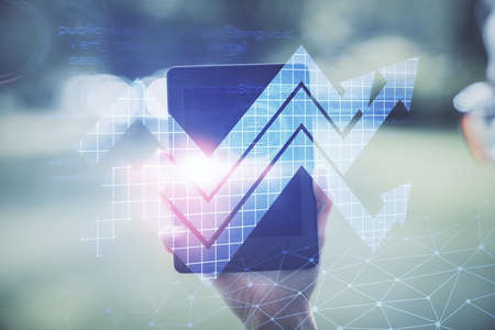 Double exposure of arrows hologram and woman holding and using a mobile device. Success concept.