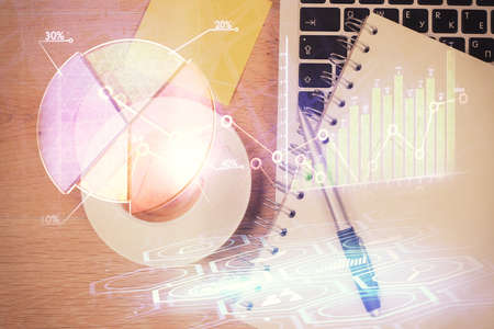 Double exposure of financial chart drawing over table background with computer. Concept of research...
