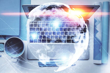 Business theme hologram drawings over computer on the desktop background. Top view. Multi exposure....