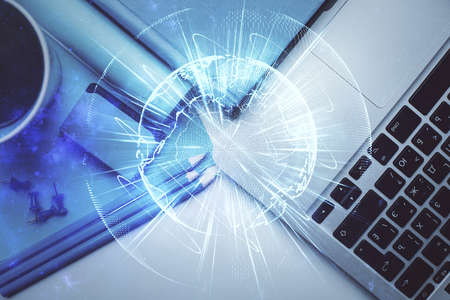 Business theme hologram drawings over computer on the desktop background. Top view. Multi exposure....