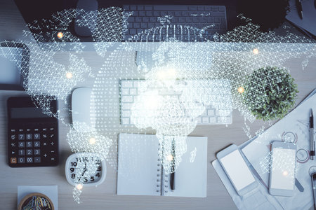 Business theme hologram drawings over computer on the desktop background. Top view. Multi exposure....
