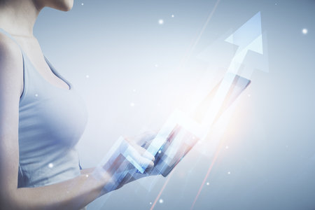 Double exposure of arrows hologram and woman holding and using a mobile device. Success concept.の写真素材