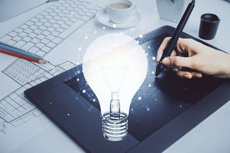 Double exposure of light bulb hologram and woman holding and using a mobile device. Idea concept.の写真素材