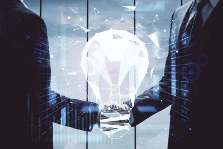 Double exposure of light bulb hologram and handshake of two men. Idea concept.の写真素材