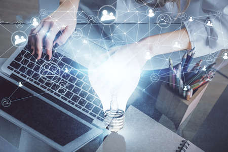 Double exposure of woman hands typing on computer and light bulb drawing. Idea concept.
