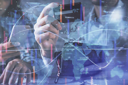 Double exposure of man and woman on-line shopping holding a credit card and business theme hologram drawing. E-commerce pay on-line concept.の写真素材