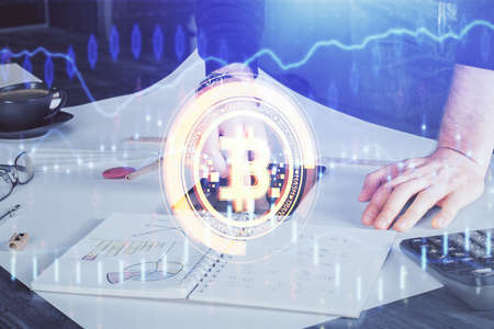 Double exposure of man's hands holding and using a phone and crypto currency blockchain theme...
